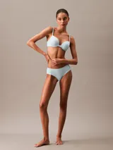 Bombacha tipo hipster de la línea invisible de Calvin Klein, confeccionada en microfibra ligera con bordes cortados a láser para un acabado sin costuras. Presenta una cobertura total en la parte trasera con costura central y el logo de la marca estampado en la cadera.