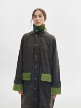 Trench oversize de lana a cuadros con cuello, puños y bolsillos de pana verde.