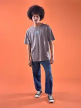 Remera gris con estampado frontal de Mickey Mouse con tipografía azul. Corte oversized.