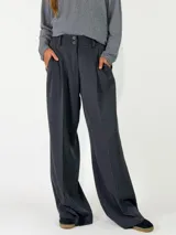 Pantalon de vestir de corte sastrero y tiro alto, con pinzas frontales, cierre de doble botón y pernera ancha.
