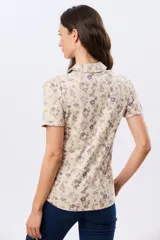 Camisa de algodón de manga corta en tejido jersey, con estampado floral de inspiración retro, cuello camisero y abertura frontal parcial con botones.