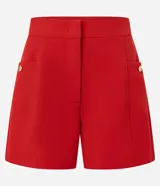 Short sastre de cintura alta color marrón, con bolsillos laterales y detalles de tachuelas metalizadas.