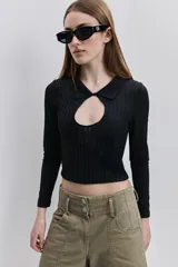 Top de calce al cuerpo color negro, confeccionado en tejido elástico con textura acanalada, con cuello camisero, mangas largas y recorte frontal tipo cut-out.