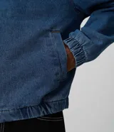 Campera estilo bomber de jean color azul, con cierre frontal, cuello camisero, puños y ruedo con elástico, de corte boxy amplio y estructurado.