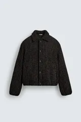 Cazadora de corte boxy fit confeccionada en tejido con textura waffle y acolchado interior. Presenta cuello solapa, cierre frontal con botones a presión, mangas largas con puños elásticos y bolsillos de vivo en la cadera.