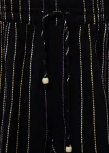 Short de corte recto con diseño de rayas verticales en tonos oscuros con detalles en lila y amarillo. Presenta bajo deshilachado y cintura elástica con cierre de lazo.