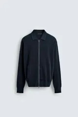 Chaqueta de punto de algodón con textura acanalada, cuello solapa, cierre frontal con cremallera y bolsillos laterales de vivo.