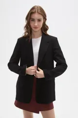 Blazer negro de corte clásico con cuello solapa, cierre frontal con botones y bolsillos laterales con solapa.