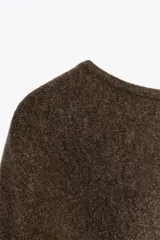 Capa de punto color marrón, con cuello redondo y diseño holgado de caída fluida.