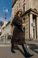 Bota alta estilo cowboy de caña alta, con tacón medio en bloque y punta fina. Presenta tiradores laterales para facilitar el calce.