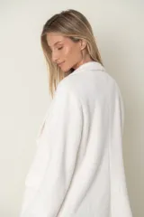 Blazer italiano color beige, de corte recto, con solapas de muesca, cierre de un botón y bolsillos simulados.