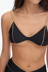 Top de bikini negro con escote en V, tirantes finos y detalles de vivos en tono tostado a contratono.