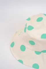 Gorro tipo bucket color crema con estampado de lunares fucsias.