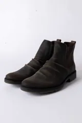 Bota tipo Chelsea de cuero color marrón oscuro con efecto desgastado, paneles laterales elásticos y suela de goma antideslizante.