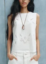 Top blanco sin mangas de algodón, con cuello redondo y detalles bordados.