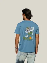 Remera de algodón color azul con estampa botánica en la espalda que representa la flor y el fruto del mburucuyá, acompañada por el nombre de la planta en tipografía vertical.