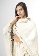 Ruana off white de tejido texturado con detalles sutiles de hilos multicolor y terminación de flecos en los bordes.