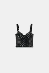 Top estilo corset con escote corazón, tirantes anchos con detalle de fruncido y cierre posterior con cremallera. Presenta un diseño de estampado de lunares en contraste.