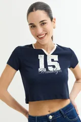 Remera crop top azul marino de manga corta, con cuello en V y ribete blanco. Estampado frontal con el número "15" y la palabra "Brooklyn" en blanco.