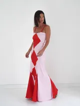 Vestido largo de corte sirena con diseño de rombos en colores púrpura y rojo. Presenta breteles finos, escote recto y una falda con caída fluida y cola corta.