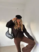 Blazer de corte recto y estructura ligera en color marrón oscuro, con cierre frontal de un botón y mangas largas.