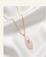 Collar de acero con baño de oro, compuesto por una cadena fina y un dije en forma de lágrima de cuarzo rosa con una circonia central.