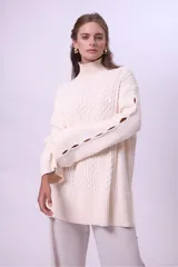 Sweater de punto color bordó con cuello alto y diseño de trenzas en el frente y las mangas. Presenta un corte holgado y largo, con puños y ruedo acanalados.