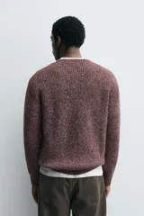 Jersey de punto perlado con ajuste relajado, cuello redondo y manga larga, con acabados en rib en puños y cintura.