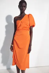 Vestido midi asimétrico de satén color naranja, con una sola manga corta abullonada, diseño drapeado en el lateral y falda cruzada.