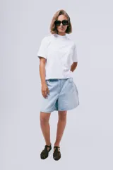 Camiseta blanca de algodón orgánico, de corte clásico con cuello redondo alto y mangas cortas.