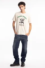 Remera de algodón color beige con estampa frontal gráfica que incluye la frase 'Todo bien' en color verde y un dibujo de una silla de oficina con texto descriptivo debajo.