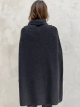 Poncho gris de lana con cuello alto y aberturas laterales con ribete blanco.