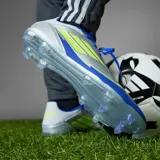 Championes de fútbol Adidas F50 League FG Messi, color plateado con detalles en azul y amarillo.