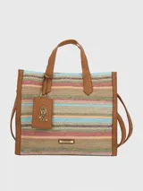 Cartera tipo tote de Hush Puppies con diseño de rayas horizontales multicolores en tejido de fibras naturales. Presenta detalles en cuero sintético color suela en los bordes, manijas y etiqueta colgante con el logo de la marca. Incluye placa metálica dorada con el nombre de la marca en la parte inferior.