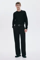 Buzo negro de punto fino con cuello redondo, mangas largas y remates acanalados en cuello, puños y bajo. Corte estándar.