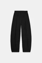 Pantalón de tiro alto con pierna ancha y cintura elástica ajustable. Presenta un diseño de corte holgado con costuras verticales frontales que definen su silueta.
