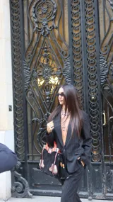 Blazer negro de corte sastrero con diseño de rayas diplomáticas verticales, cierre frontal de un botón y bolsillos laterales con solapa.