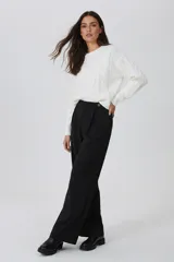 Sweater de punto con diseño de ochos, cuello redondo a la base y mangas largas. Presenta un corte holgado y textura suave.