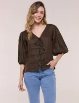 Blusa de lino color marrón, de calce relajado, con escote en V pronunciado, cierre frontal con lazos y mangas abullonadas tres cuartos.