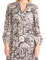 Vestido maxi de gasa estampada en blanco y negro, marca Julia Jordan. Escote en V, hombros con fruncidos, mangas largas amplias con puños elastizados. Cintura con faja ancha de punto smock y falda escalonada con vuelo. Cierre invisible y botones metálicos en la espalda. Forro interno a tono.