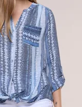 Blusa de gasa Zac & Rachel con estampado de rayas verticales en tonos rosados, amarillos y blancos. Presenta escote en V con cuello mao, cierre frontal con botones, un bolsillo aplicado en el pecho, mangas largas con presilla para regular el largo y detalle de nudo en el dobladillo inferior.
