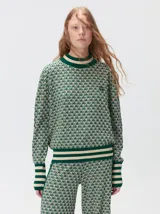 Sweater de tejido de punto jacquard con diseño geométrico, cuello redondo y puños acanalados en contraste de color verde y beige.