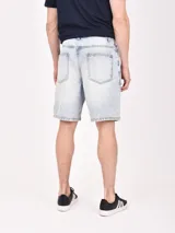 Bermuda de jean en color celeste lavado, con diseño de corte recto y detalles de roturas desgastadas en la parte frontal.