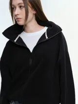 Campera de tela fleece doble, color negro, con cierre frontal completo, cuello alto y bolsillos laterales. Presenta puños y bajo elastizados para un ajuste cómodo.