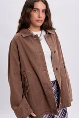 Campera de jean color marrón con efecto lavado, cuello camisero, cierre frontal con botones y bolsillos laterales.