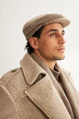 Boina con visera de lana fina uruguaya natural, sin teñir, con diseño de tejido texturizado en tonos beige y marrón.