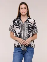 Camisa de gasa de manga corta con estampado en blanco, negro y beige, cuello con solapa, cierre frontal de botones y diseño con nudo en el ruedo.