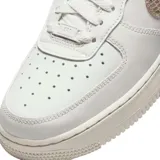 Championes Nike Air Force 1 de corte bajo, color blanco con detalles en textura de piel de serpiente en tono bronce en el swoosh lateral y en el talón.