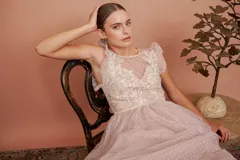 Vestido largo de tul plumetí en color rosa suave, con detalles de encaje bordado en el torso y volados en los hombros.