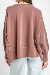 Sweater de algodón peinado con efecto lavado, de corte oversize, cuello redondo y mangas largas con costuras visibles.